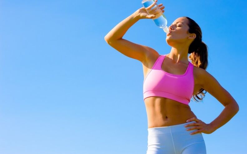 A sports girl drinks water